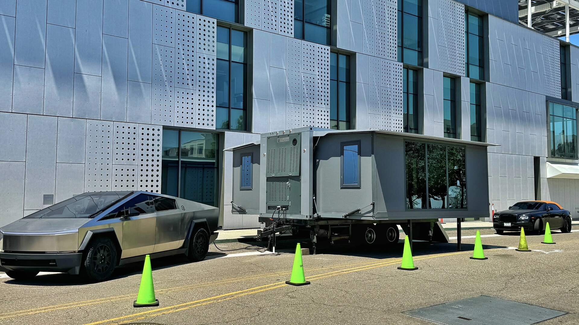 Rear view of an unfolded prefab home on a private rural lot with side-panel deployment visible.